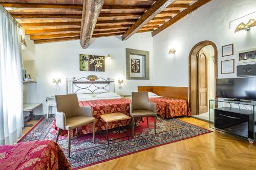 佛罗伦萨科洛迪佛罗伦萨酒店的一间卧室配有一张床、两把椅子和电视