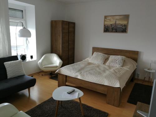 米什科尔茨Ida Apartman的一间卧室配有一张床、一张沙发和一把椅子