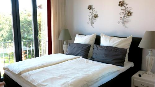 巴贝"Bellevue" Villa Andrea的卧室配有带枕头的白色床和窗户。
