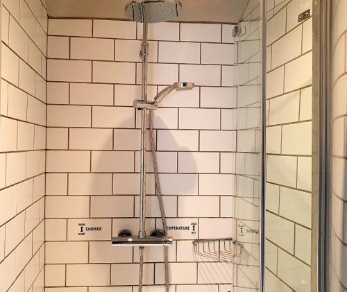 PensfordThe Carpenters Arms的浴室设有白色瓷砖墙壁和淋浴。