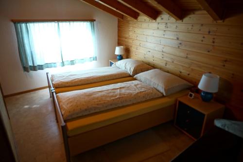 萨沃宁Tgaplotta - mit Lademöglichkeit Elektroauto的卧室配有木墙内的一张床