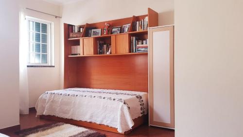 韦拉斯Casa dos Rui´s的一间卧室设有一张床和一个书架