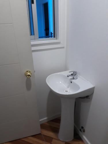 库里科Hostal Alessandri的一间带白色水槽和窗户的浴室