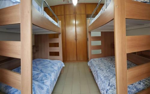 桑托斯Apto Pé na Areia Santos的客房设有两张双层床和一张床。