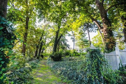刘易斯顿Niagara Mansion Carriage Suite的花园拥有白色的围栏和树木