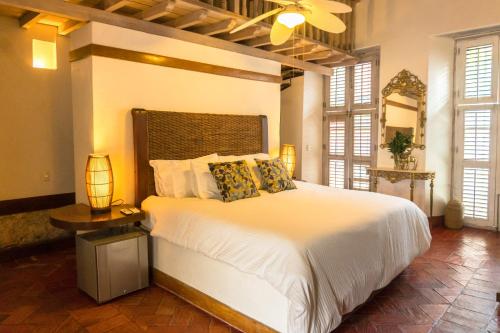 卡塔赫纳Hotel Casa la Tablada的卧室配有一张白色的大床和一张桌子