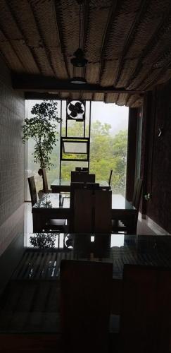 阿努拉德普勒拉雅拉塔度假酒店的一间带桌椅和大窗户的用餐室