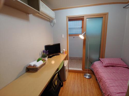 首尔I sleep alone的一间卧室配有一张床和一张带电脑的书桌