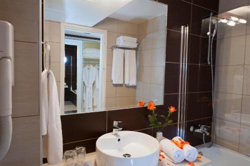赫索尼索斯Grand Hotel Holiday Resort的一间带水槽和淋浴的浴室