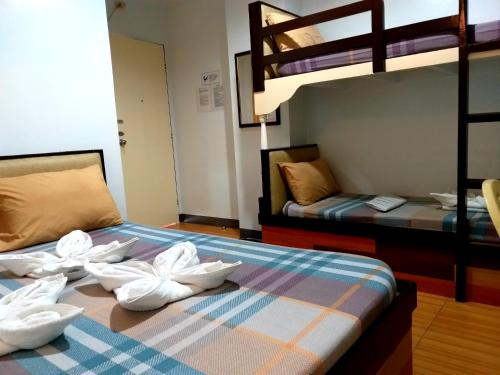 马尼拉Sola Eleganza Apartelle的一间卧室配有两张双层床,床上配有毛巾