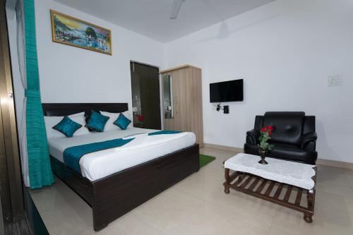 孟买Aristo Hospitality Services Apartment, 1402,14th Floor的一间卧室配有一张床、一把椅子和电视。