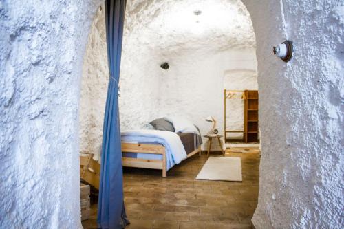 格拉纳达Cueva de Lindaraja的卧室配有一张石墙床