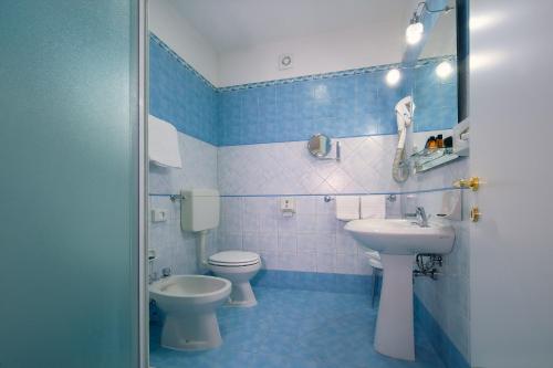 摩德纳CDH Hotel Modena的蓝色和白色的浴室设有卫生间和水槽