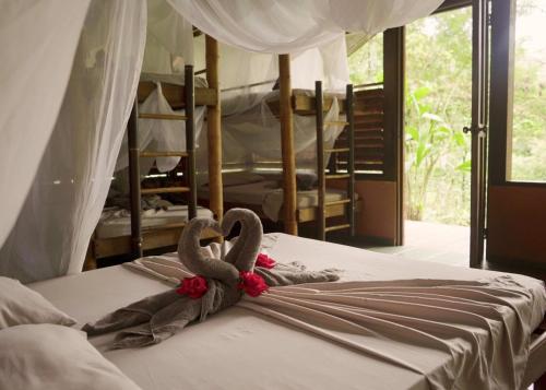 Dos BrazosAmazonita Ecolodge的一张床上有两只天鹅的睡床