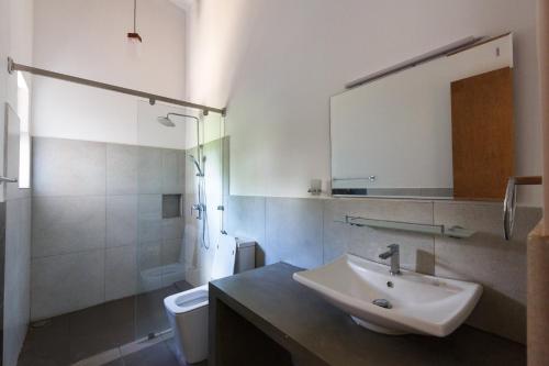 帕西库达Blue Sands Beach Resort的一间带水槽、卫生间和镜子的浴室