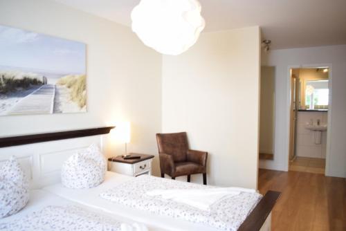 哈夫克鲁格Villa Ocean Place的白色卧室配有床和椅子
