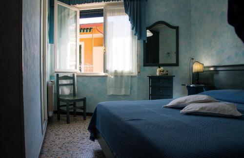 博纳索拉camere Caterina的一间卧室设有一张床、一个窗口和一把椅子