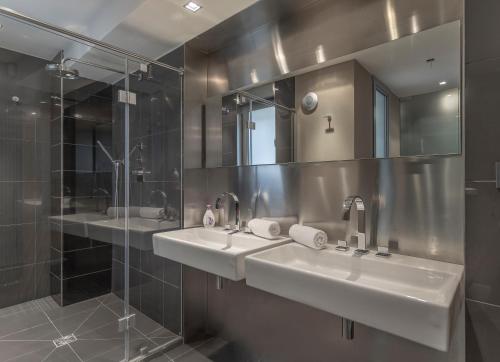 布拉格LUXURY CENTRAL DUPLEX WITH TERRACE的一间带两个盥洗盆和淋浴的浴室