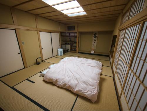 Nanakita富谷緑水庵茶道体験的一间大房间,地板上设有一张白色的床