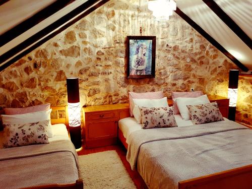VrgoracEthno Village Kokorici的一间卧室设有两张床和石墙