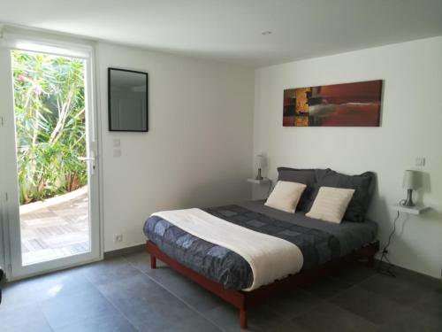马赛Villa Cottreau的一间卧室设有一张床和一个滑动玻璃门