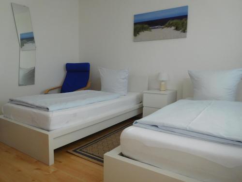 布尔格韦德尔Arkadia Hotel的一间卧室配有两张床和一张蓝色椅子