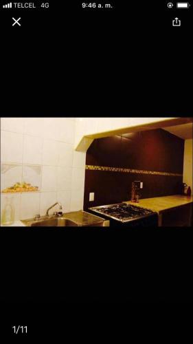 图斯特拉古铁雷斯casa cómoda y céntrica的厨房配有水槽和炉灶 顶部烤箱