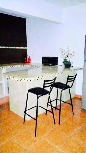 图斯特拉古铁雷斯casa cómoda y céntrica的厨房配有两把椅子和白色台面