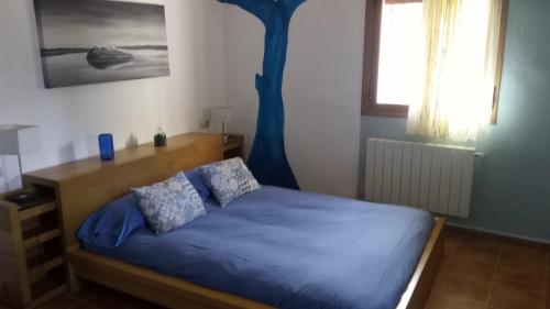 昆卡Casa Rural Mirabueno的一间卧室配有一张带蓝色床单和一棵树的床。