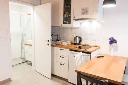 科佩尔Koper2stay的厨房配有白色橱柜和木桌
