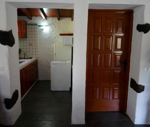 戈梅拉岛圣塞瓦斯蒂安CASA RURAL LOS FRONTONES的厨房设有红色的门和冰箱