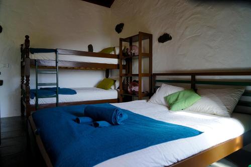 戈梅拉岛圣塞瓦斯蒂安CASA RURAL LOS FRONTONES的一间卧室配有两张双层床,铺有蓝色床单。