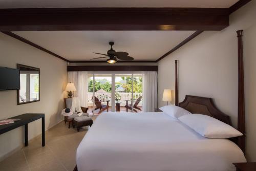 圣斐利-银港Cofresi Palm Beach & Spa Resort - All Inclusive的一间带白色床的卧室和一间用餐室