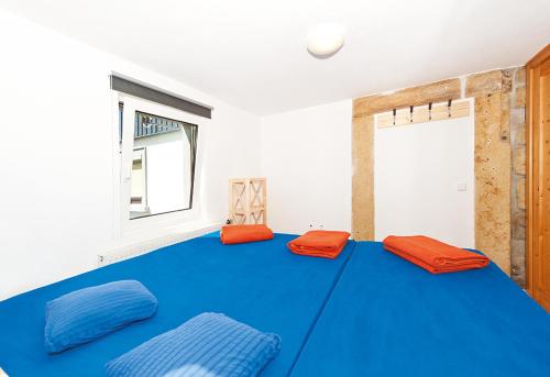 MittelndorfBergoase Hütte und Hostel Sauna Kamin Lagerfeuer的配有带橙色靠垫的大型蓝色床的房间