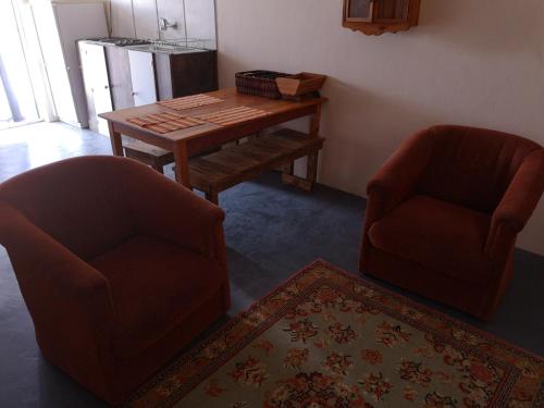 博福特西Kalamata的客厅配有两把椅子和一张木桌