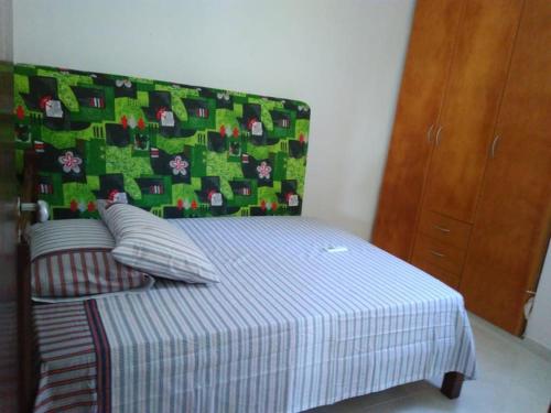 若昂佩索阿Ótimo apto Praia Bessa的一间卧室配有一张带绿色和白色毯子的床