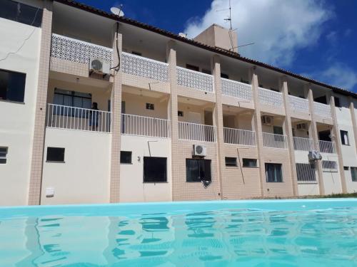 盖比姆Ap aluguel no Guaibim的大楼前设有游泳池的酒店