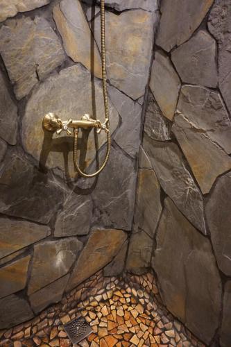 丘利利亚CASA DEL ARTE casa rural的浴室设有带淋浴的石墙