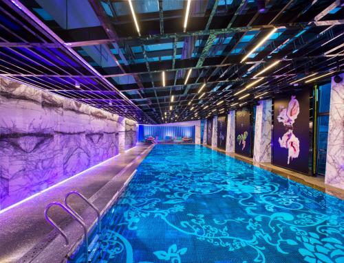 北京北京索菲特大酒店的一个带紫色照明的游泳池和一个大型游泳池