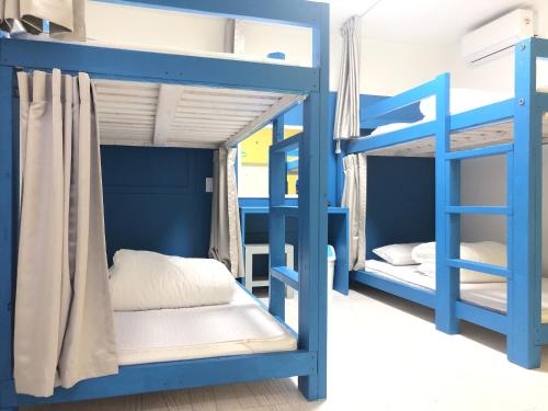 西归浦市Slow Citi Guest House的一间卧室配有蓝色双层床。