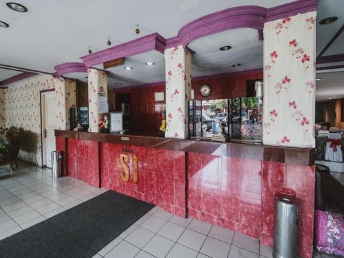 雅加达RedDoorz Plus near RSCM Jakarta的餐厅内的酒吧拥有红色和紫色的墙壁