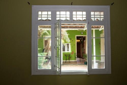 圣何塞Casa Mayela Guest House的开放式窗户,眺望外面的庭院
