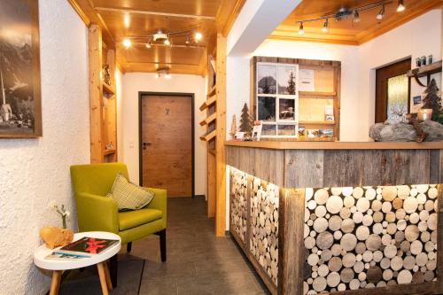 希洛谢克Alp-Chalet的客厅配有绿色椅子和柜台