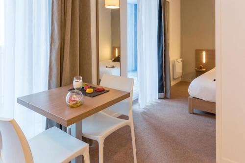 圣纳泽尔Appart'City Confort Saint-Nazaire Océan的一间带桌椅的房间和一间卧室