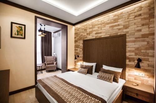 索契SIMPLE HOTEL的一间卧室设有一张大床和砖墙