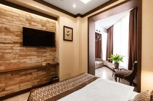 索契SIMPLE HOTEL的一间卧室设有砖墙,配有电视