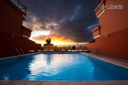 圣地亚哥港7Lizards - Ocean View Apartments的一座享有日落美景的大型游泳池