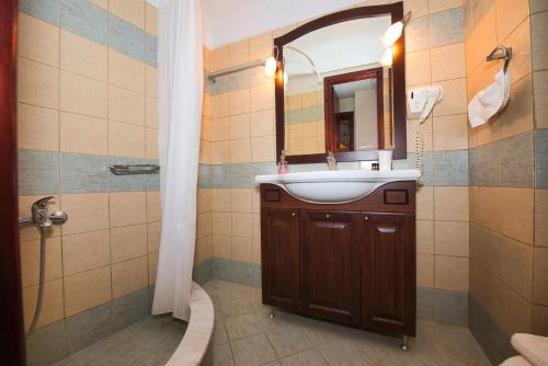 米莱艾Anemoessa Traditional Guesthouse的一间带水槽、镜子和淋浴的浴室