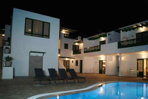 蒂亚斯Apartamentos Zalabar的晚上在酒店前面的一个游泳池