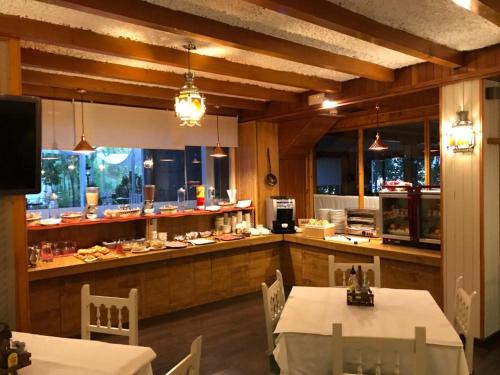 皮诺斯赫尼尔杜求斯酒店的厨房配有2张桌子和1个带食物的柜台